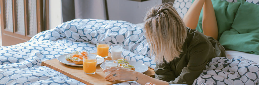 Bild som illustrerar en hotellgäst med frukostbricka